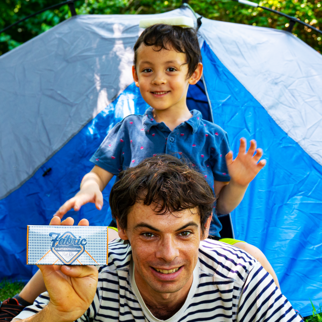 Max with fabric waterproofer in front of a tent